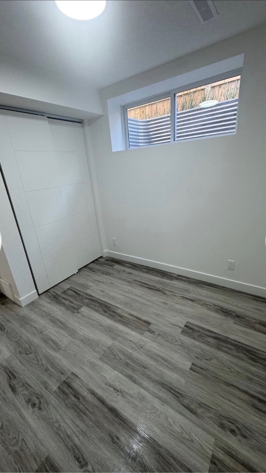 Calgary basement secondary suite bedroom with egress window by Timeless Interiors Ltd