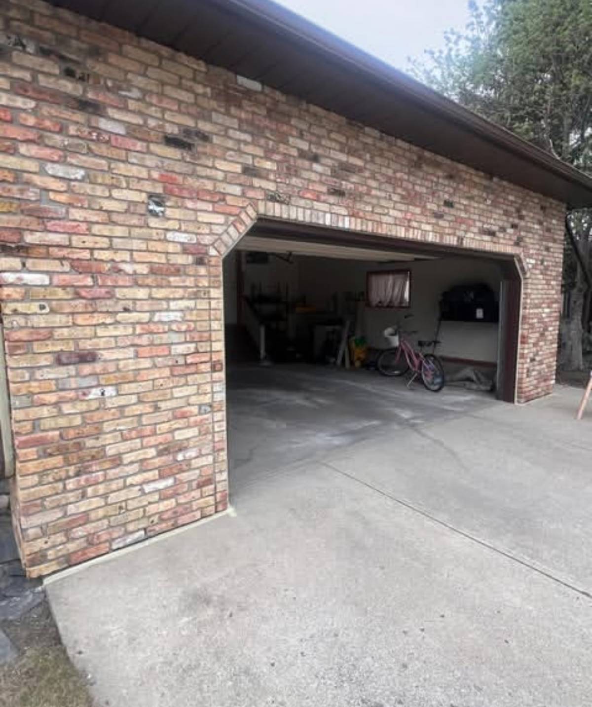 Detached garage in mixed red and buff brick before painting — Calgary brick painting by Timeless Interiors Ltd